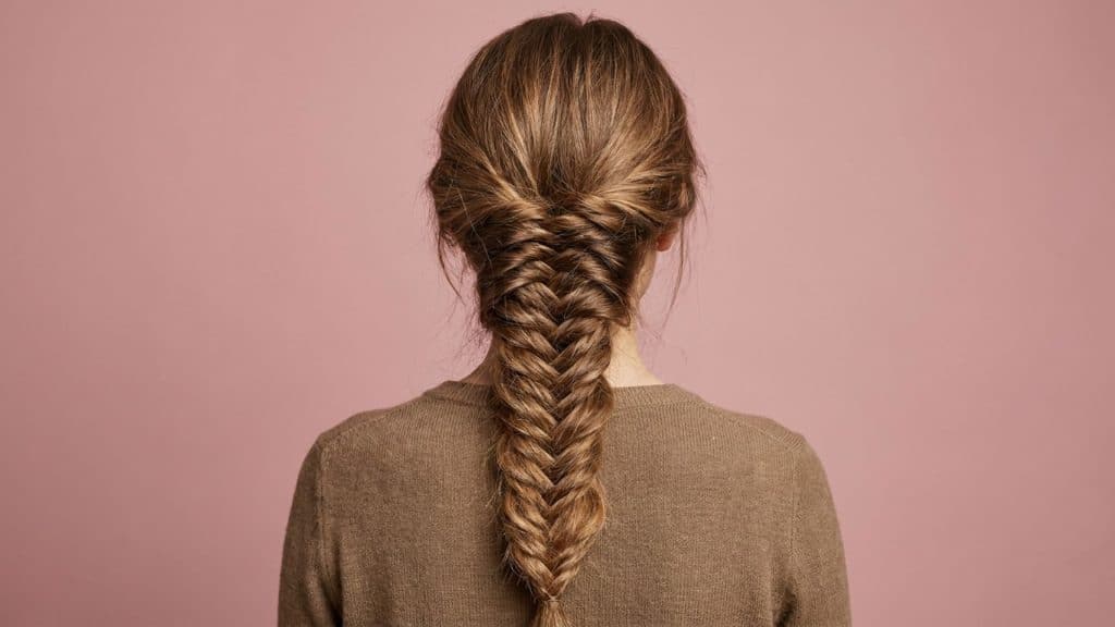 Back view of a detailed fishtail braid featuring a textured woven pattern made with small hair sections