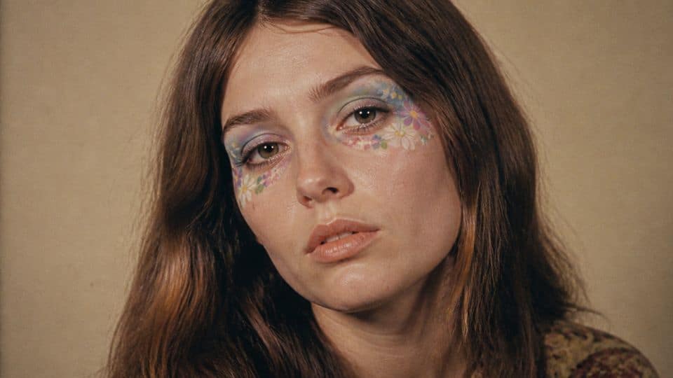 Creative 60s makeup with colorful eye details, handmade flower accents, and retro bohemian styling