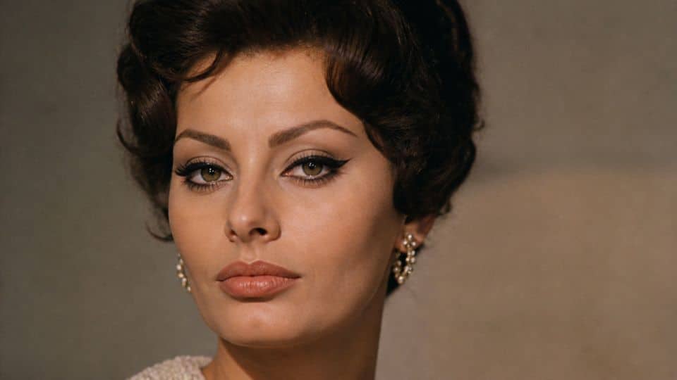 Sophia Loren inspired 60s makeup with extended cat eye liner, dramatic lashes, sculpted brows, and nude lipstick