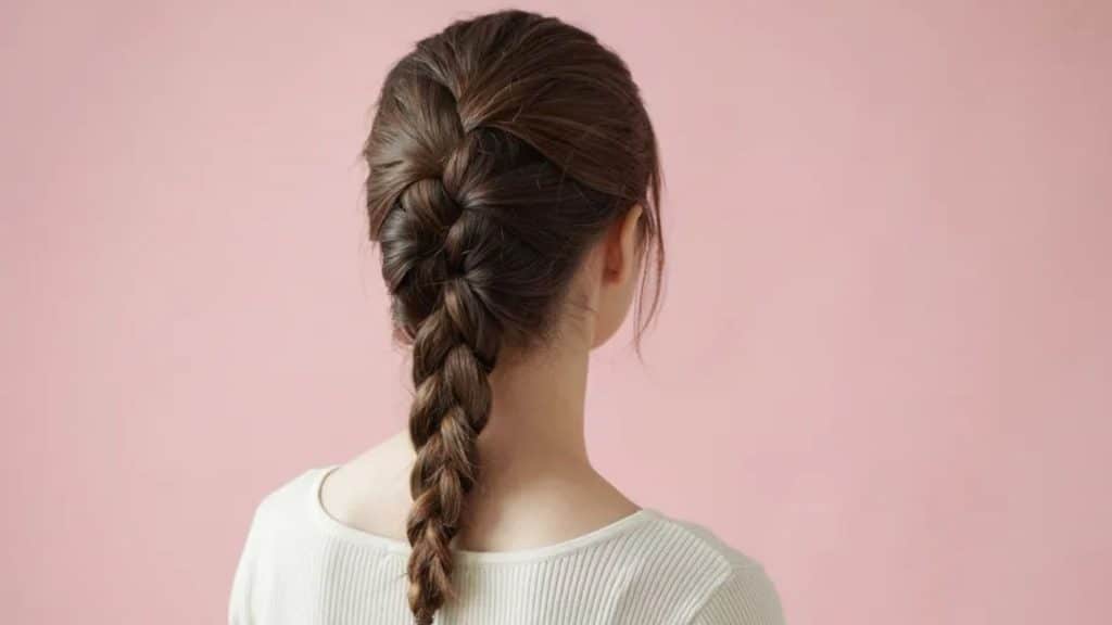 Back view of a classic three strand braid with evenly woven sections and a simple timeless hairstyle
