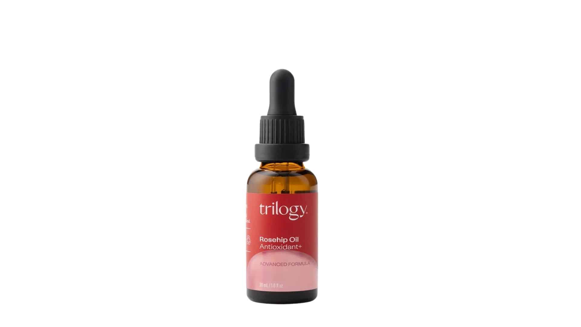 A small amber glass bottle with a black dropper cap, containing Trilogy Rosehip Oil Antioxidant+ (Advanced Formula, 30 mL / 1.0 fl oz).