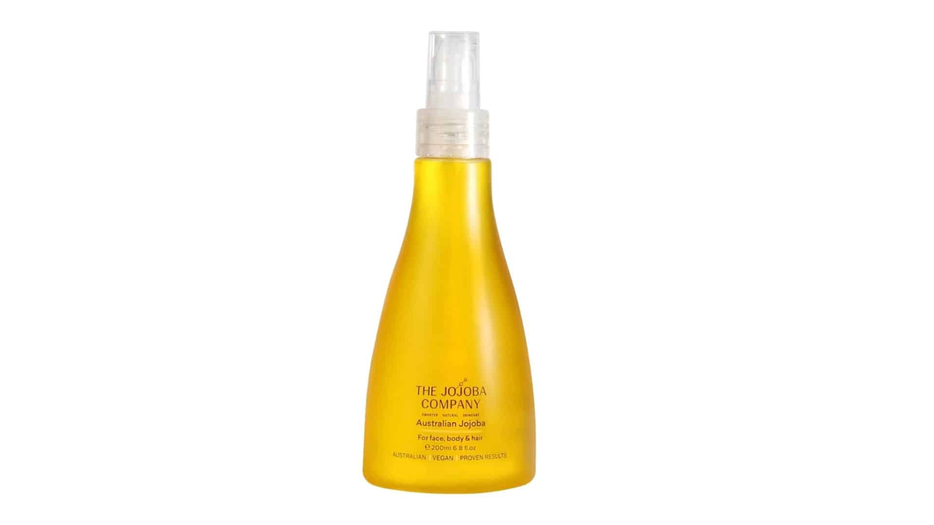 A yellow bottle of The Jojoba Company Australian Jojoba oil with a spray nozzle.