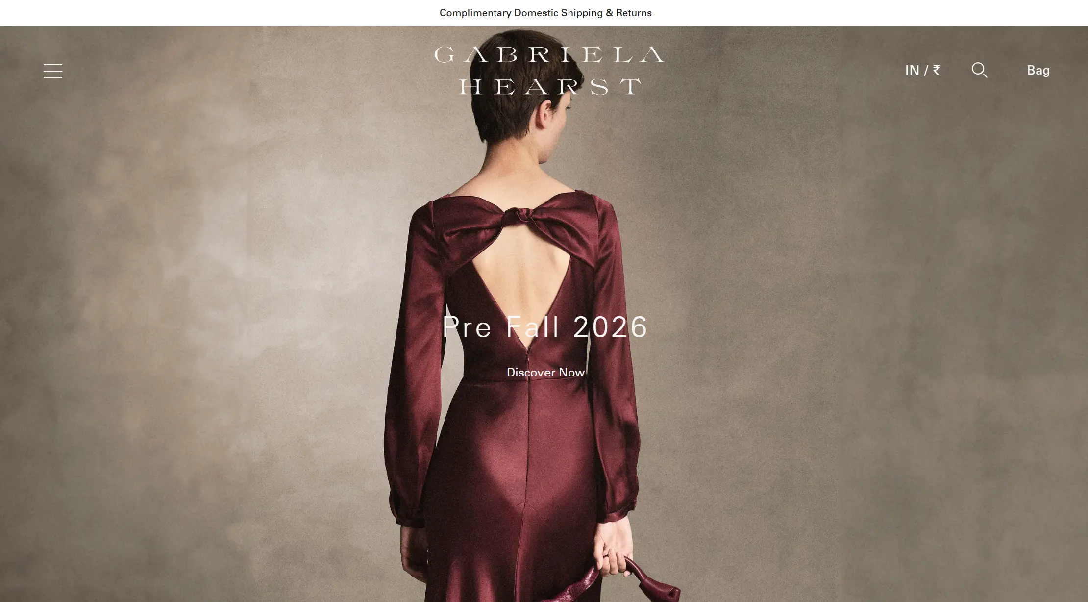 Back view of a woman wearing an open-back burgundy dress with