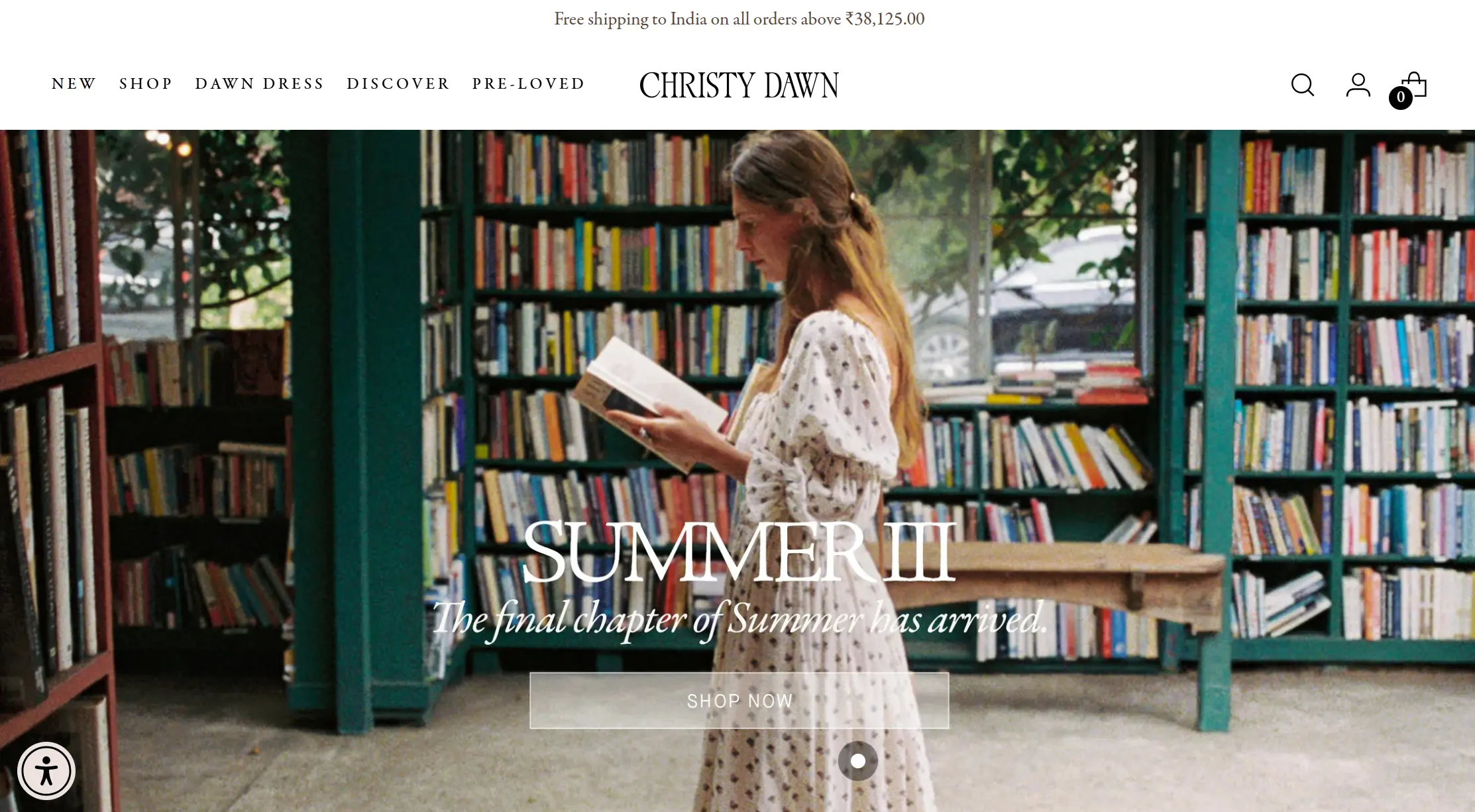 Christy dawn homepage with a woman standing in a bookstore reading a book, wearing a long, white floral dress.