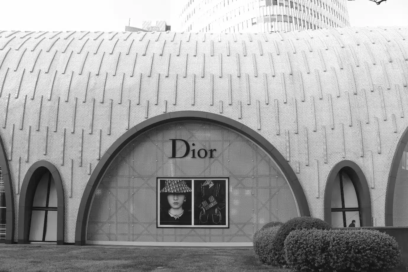 Curved building facade with Dior logo and fashion display in black and white