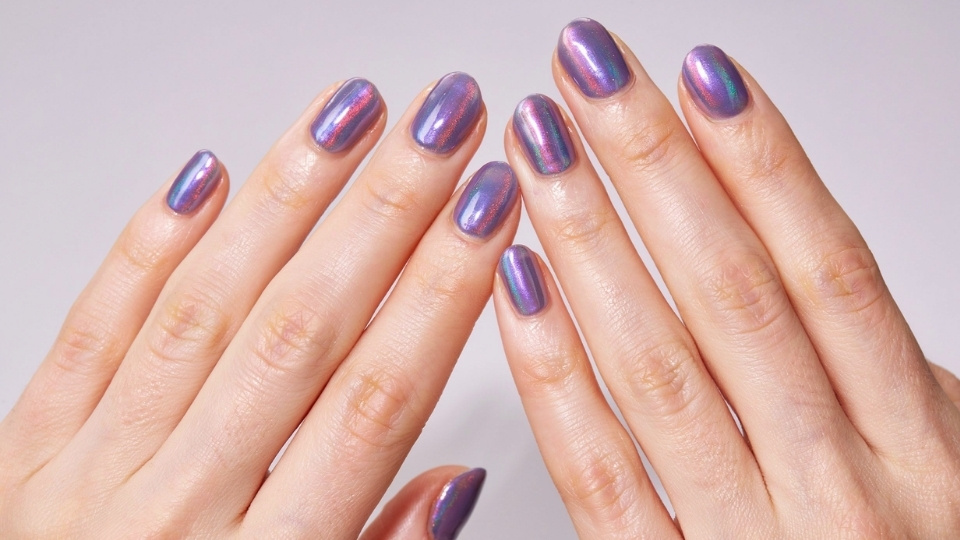 Round nails with iridescent lilac polish showing soft purple pink and silver reflective tones