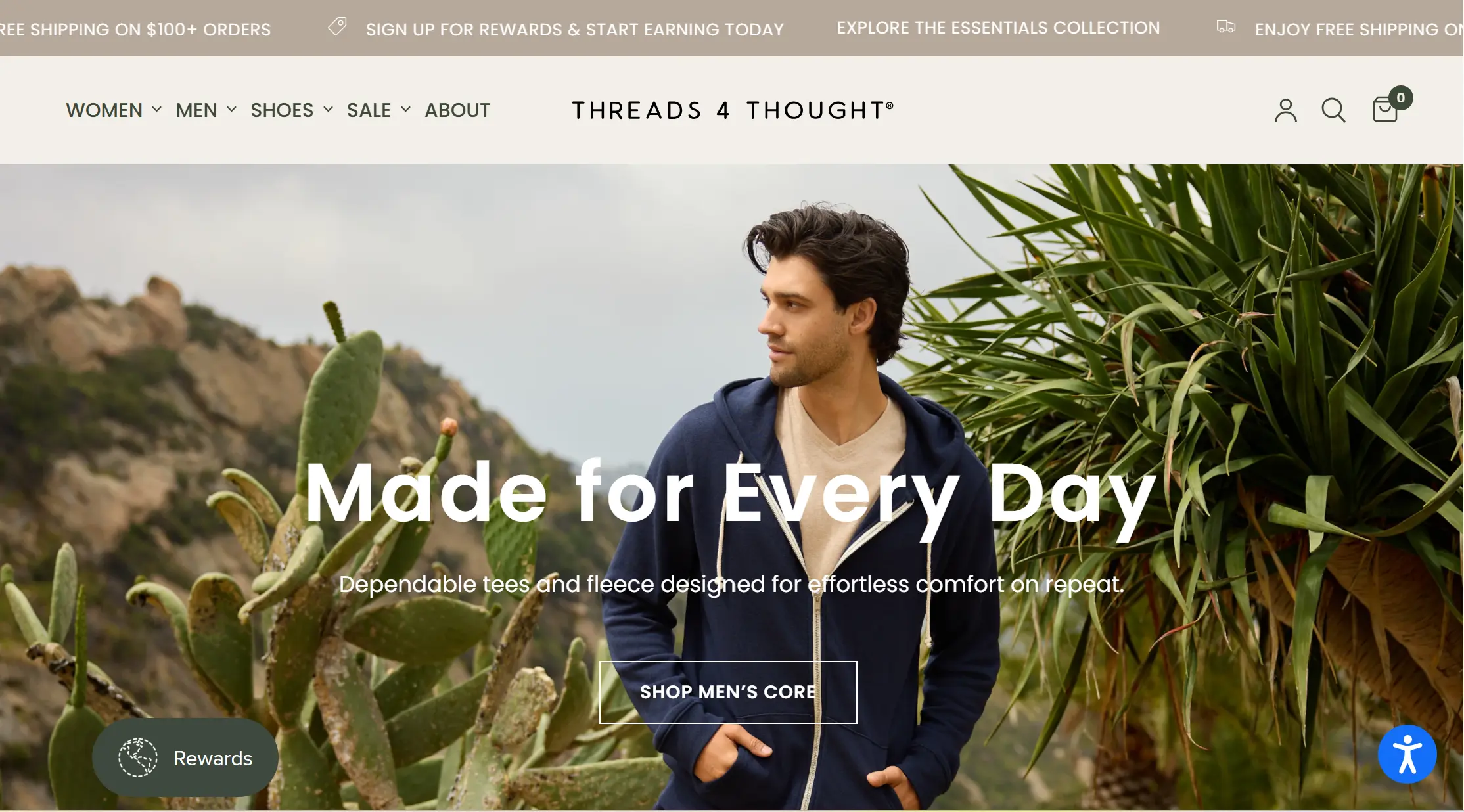 Man in a navy zip-up hoodie amidst desert plants with
