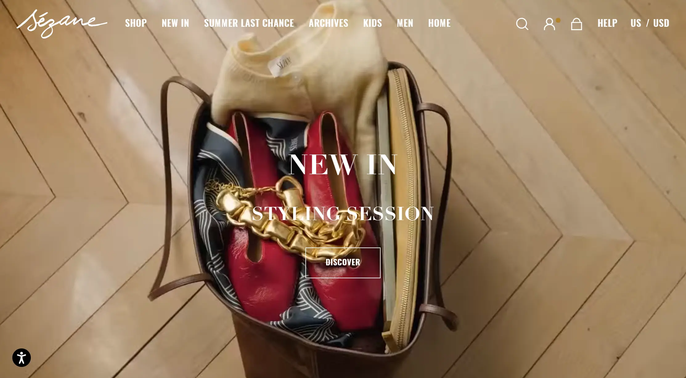 Sézane homepage banner showing a leather tote bag filled with shoes, accessories, and clothing.