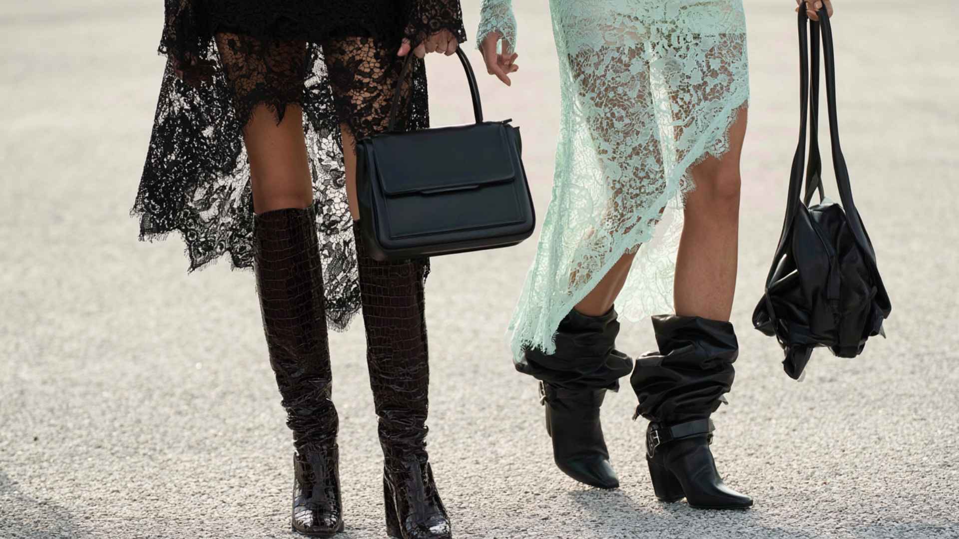 Two people wearing black cowboy boots with lace dresses and handbags showcasing stylish western inspired fashion outfits