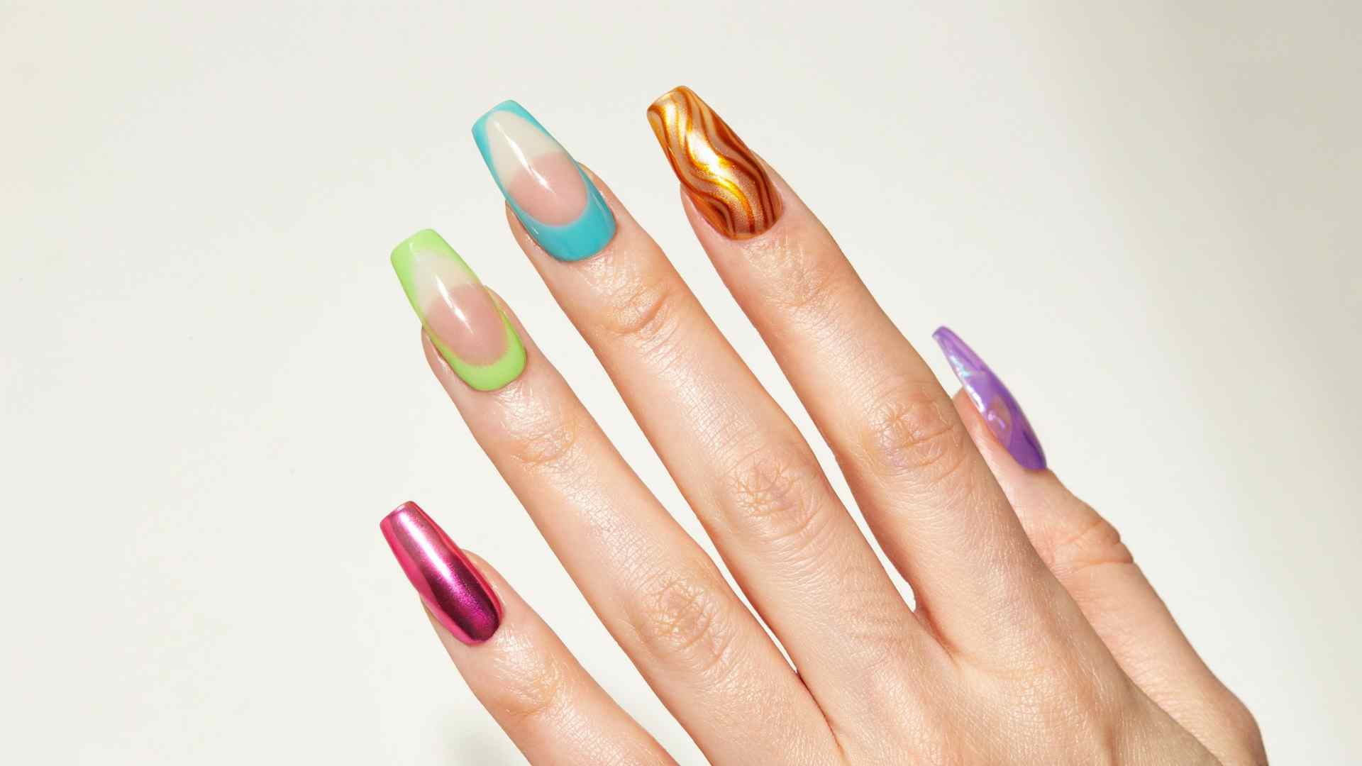 Mismatched neon chrome nails combine pink lime turquoise orange and purple designs across long coffin shaped tips