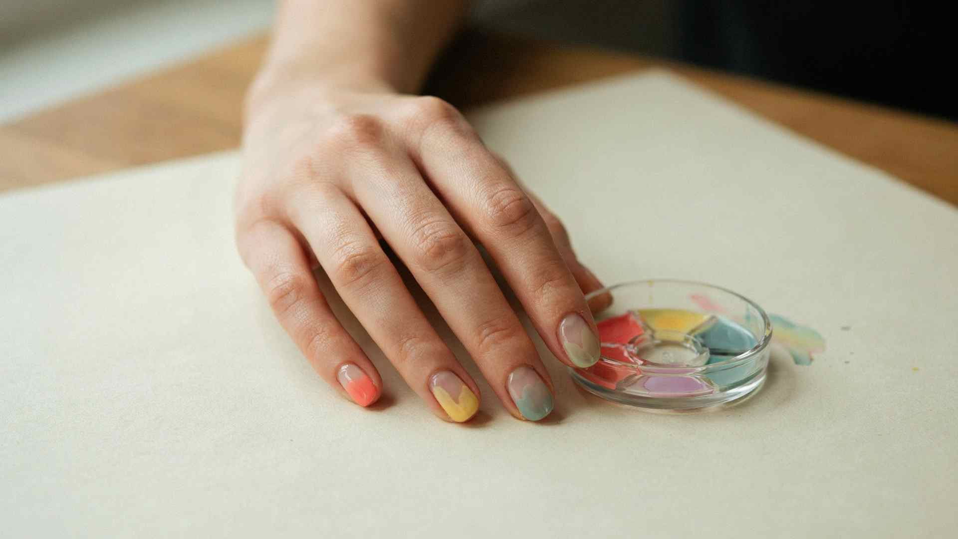 Neon watercolor washes in pink yellow aqua lime and lilac float across short oval nails with a sheer natural base