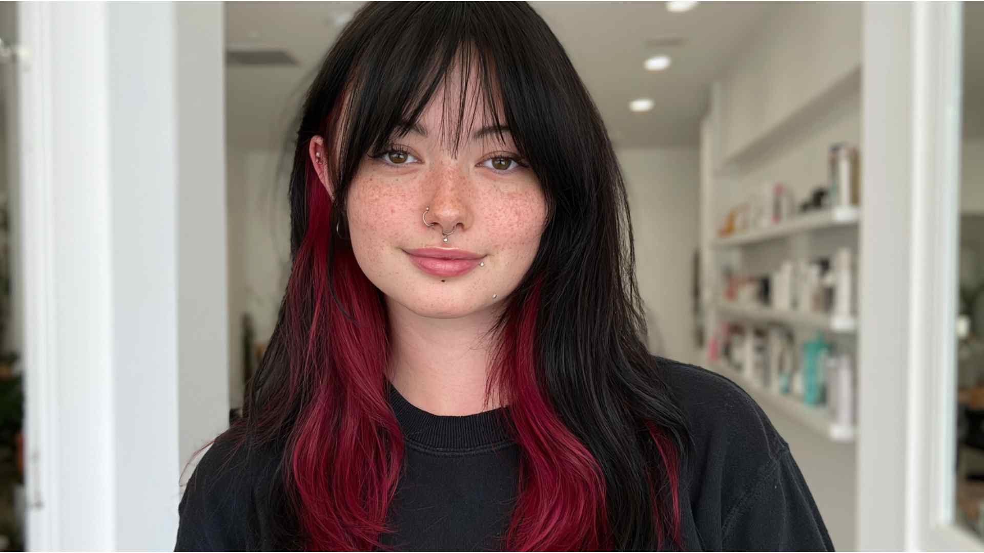 Woman with red and black hair wearing a bold short alternative haircut with choppy textured layers