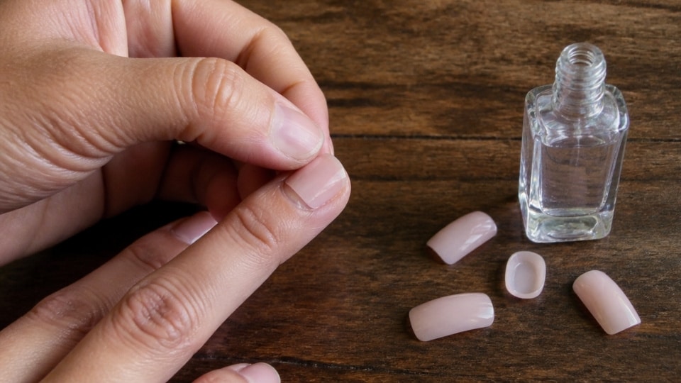 Press on nail application using clear polish layers as a short term nail glue alternative