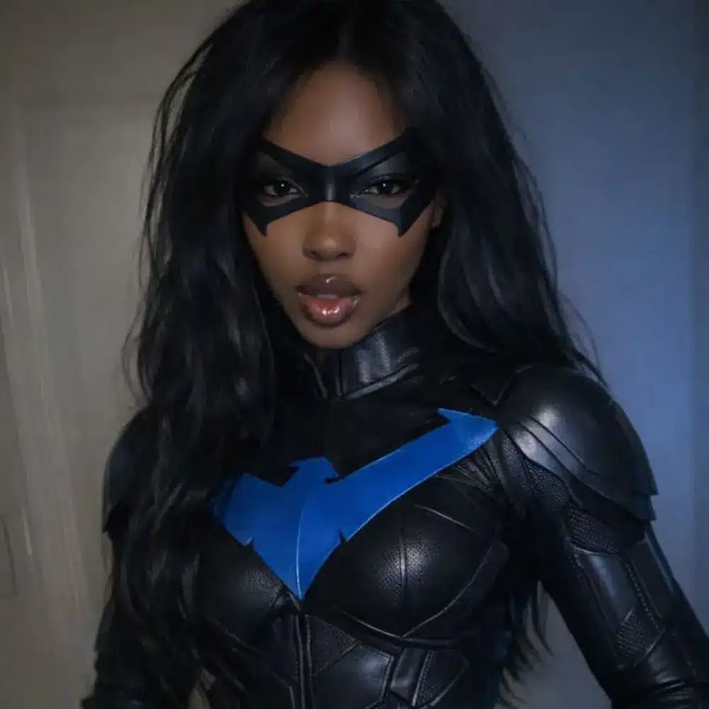 Bat Woman makeup with smoky black eyes, sharply sculpted cheeks, a sharp jaw, deep red lips, and a chic mask effect