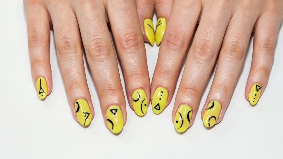 Neon yellow nails with black graphic lines and modern abstract geometric nail art