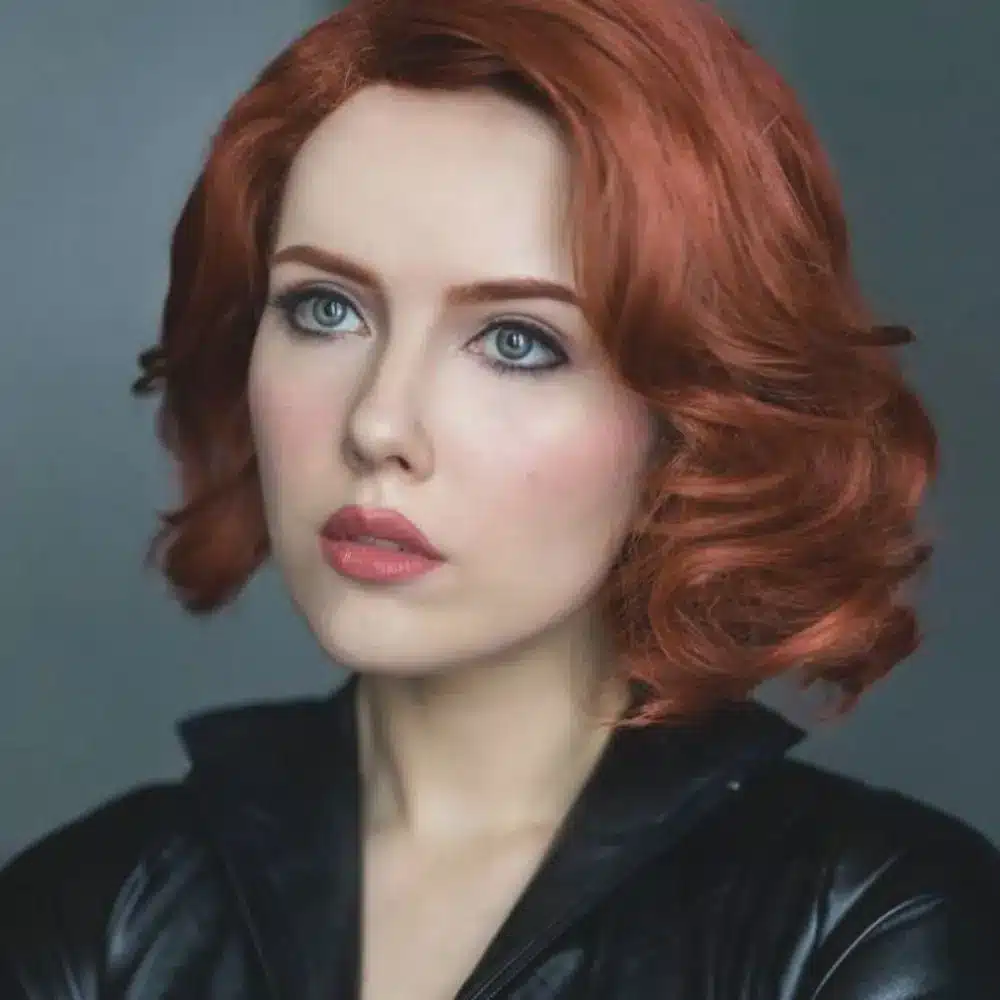Black Widow makeup with a smooth matte base, blended black and grey smoky eyes, precise liner, lashes, and red lips
