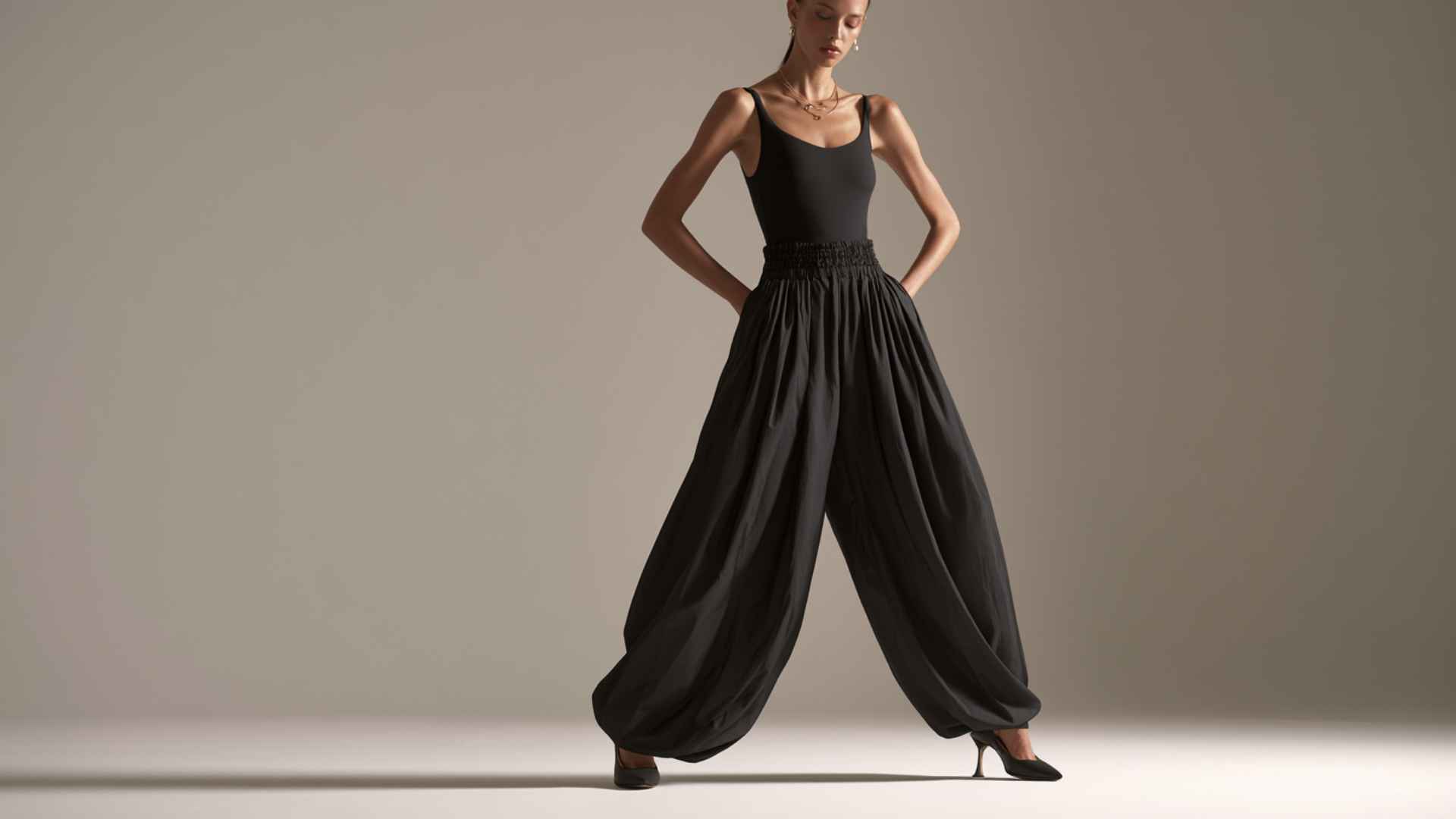 Woman wearing parachute pants with a fitted bodysuit and heels for a polished evening outfit.