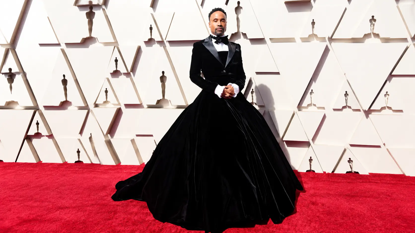 Camp fashion shown by Billy Porter in a black tuxedo gown blending masculine tailoring with dramatic red carpet styling