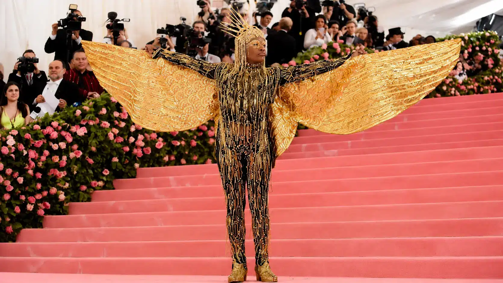 Camp fashion showcased by Billy Porter in a gold winged outfit with theatrical styling on the Met Gala pink carpet