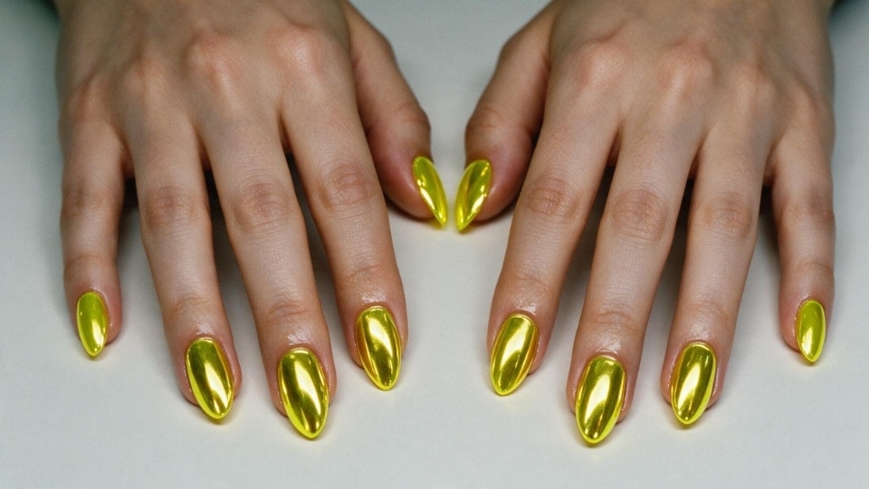 Neon yellow chrome nails with a reflective metallic finish and futuristic glossy manicure style