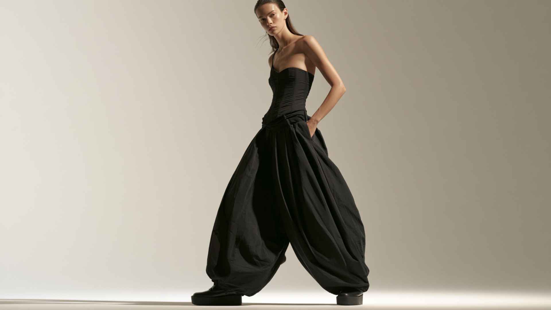 Woman pairing wide-leg parachute pants with a fitted corset top for a Y2K-inspired outfit.