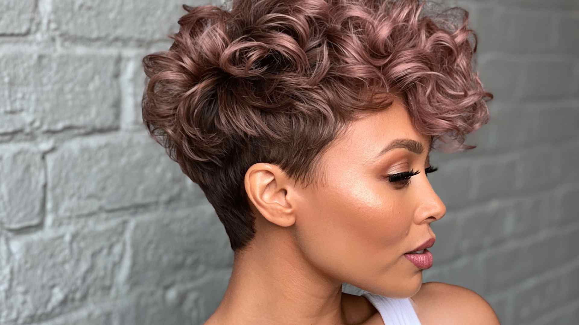Curly short haircut with longer curls on top and an undercut at the sides
