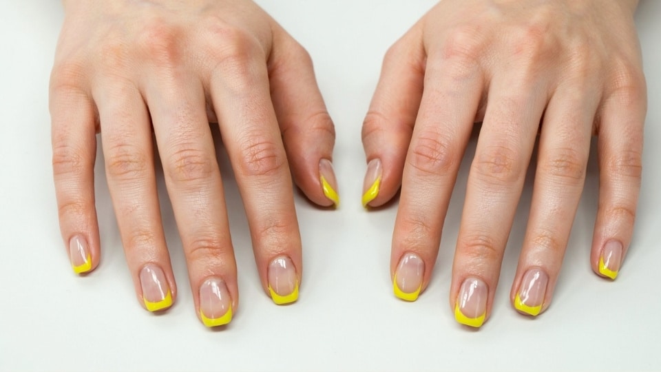 Bold neon yellow French tip nails with thick glowing edges and a modern statement manicure