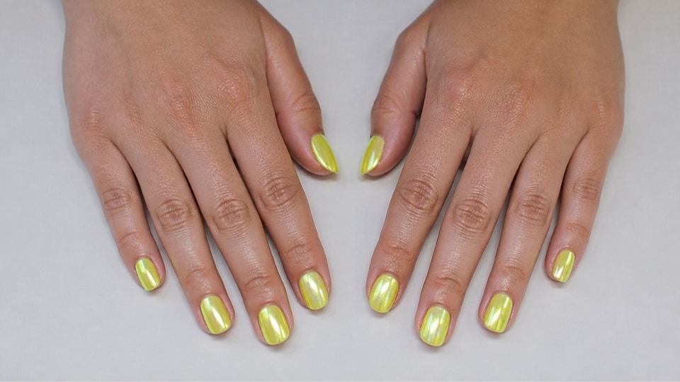 Glazed neon yellow chrome nails with a pearly shine and smooth glass like manicure finish