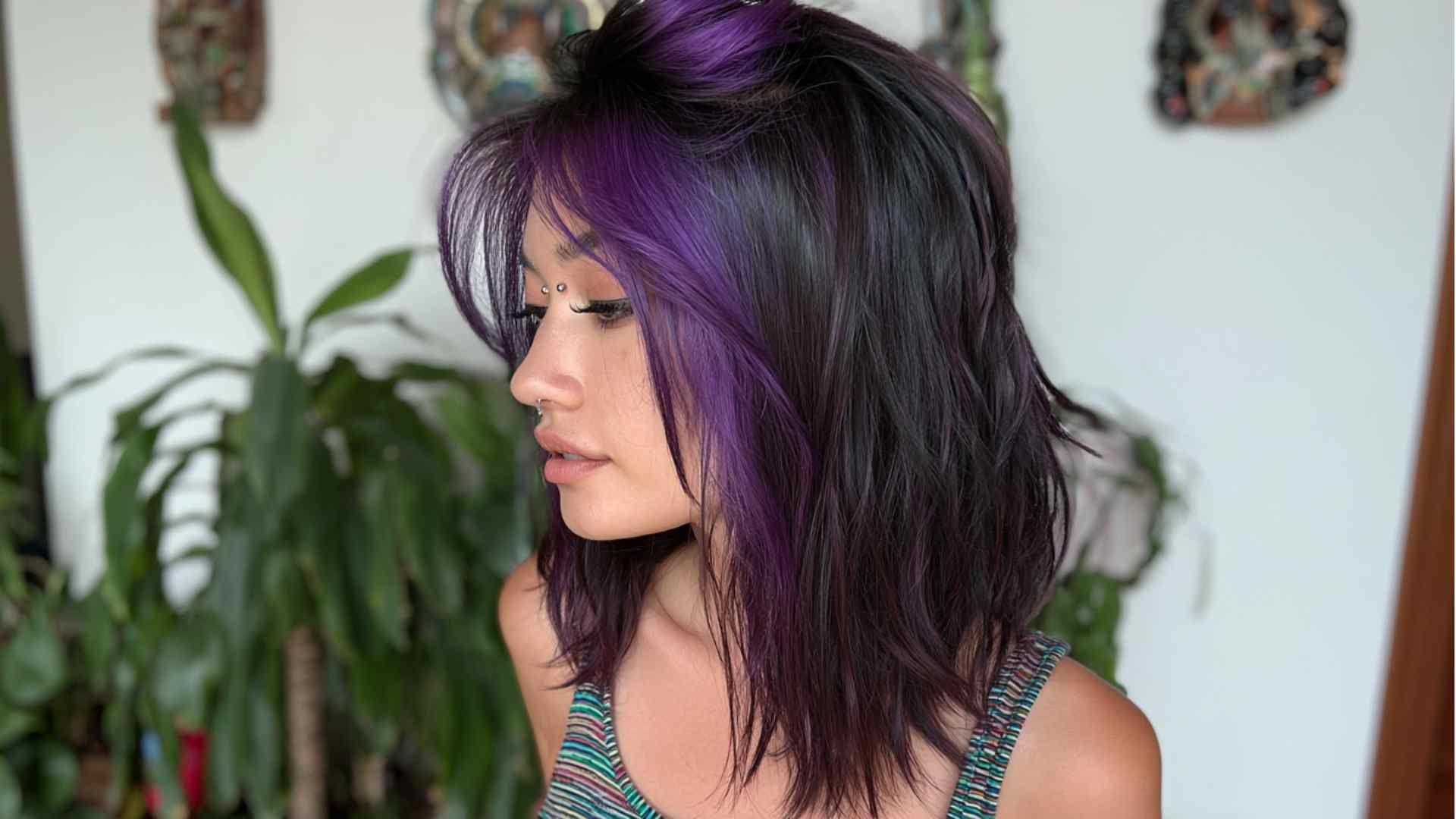 Layered grunge hairstyle with faded bold color and dark roots