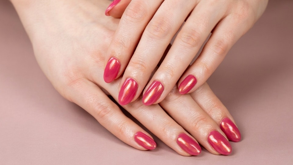 Hot pink cat eye nails with glowing magnetic shimmer lines and a glossy dimensional finish on almond nails