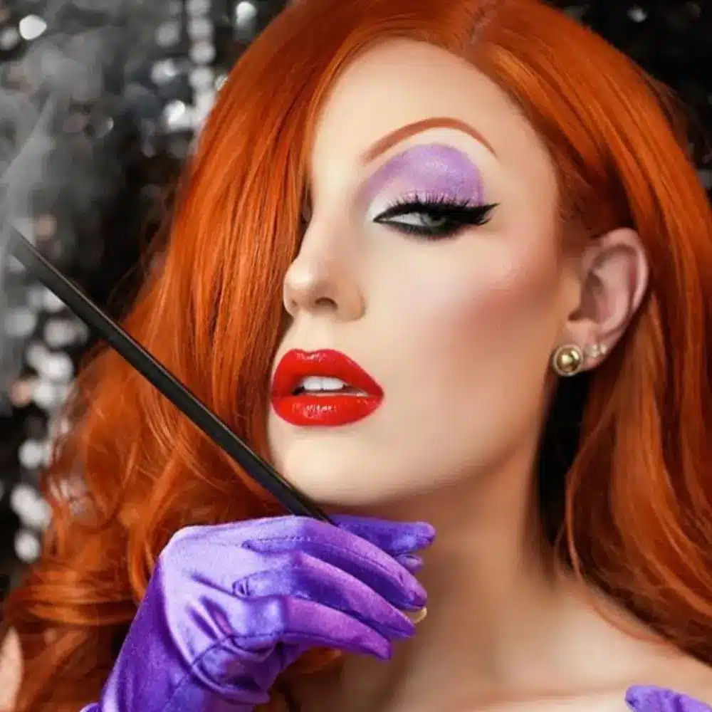 Jessica Rabbit makeup with golden glowing skin, smoky red brown eyes, dramatic lashes, and glossy deep red lipstick