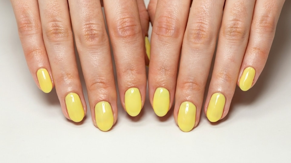 Matte neon yellow nails with a soft velvet finish and subtle lemon inspired manicure details