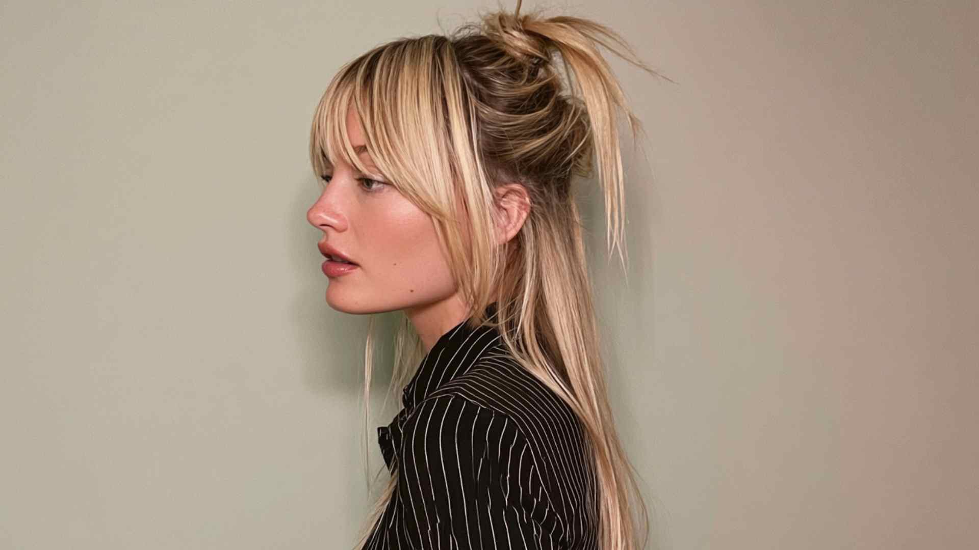 Messy grunge ponytail with loose strands, textured volume, and face-framing pieces