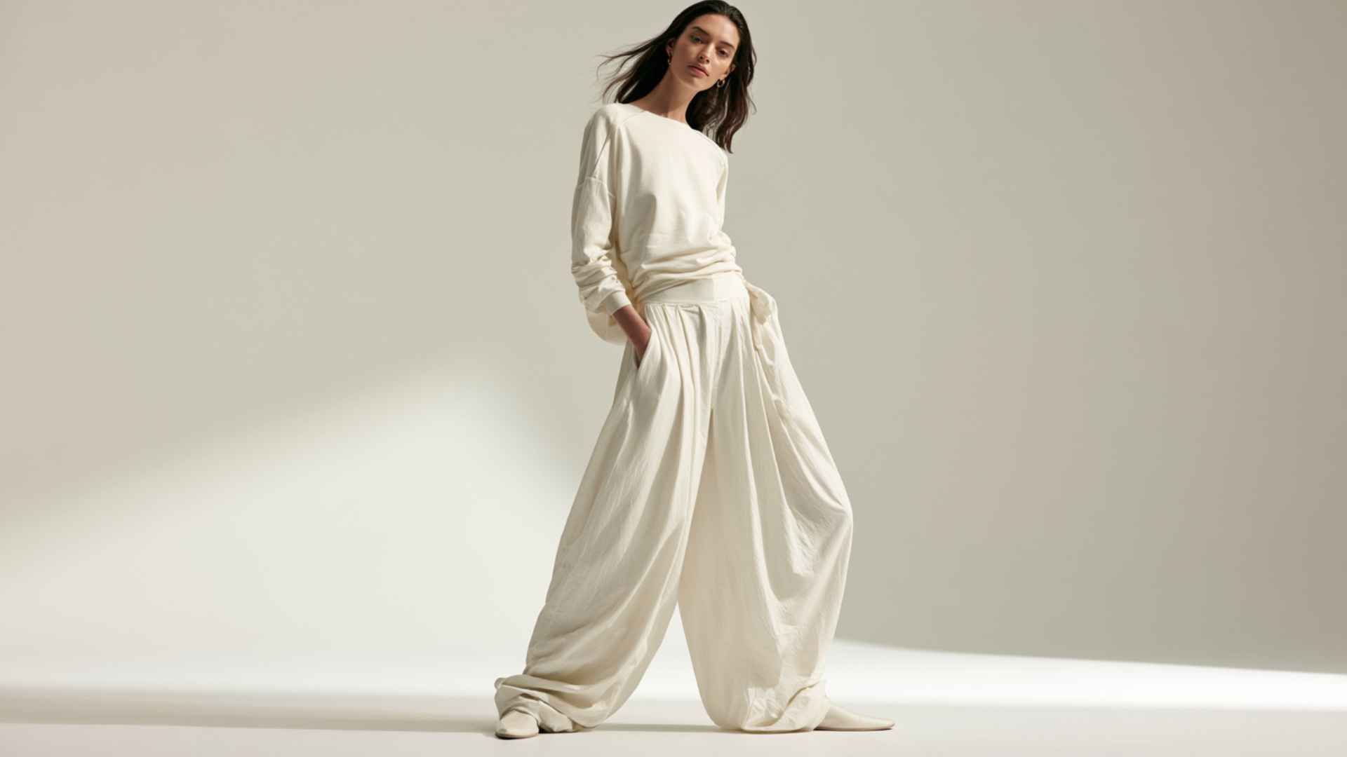 Woman wearing a monochrome outfit with wide-leg parachute pants and a fitted matching top.