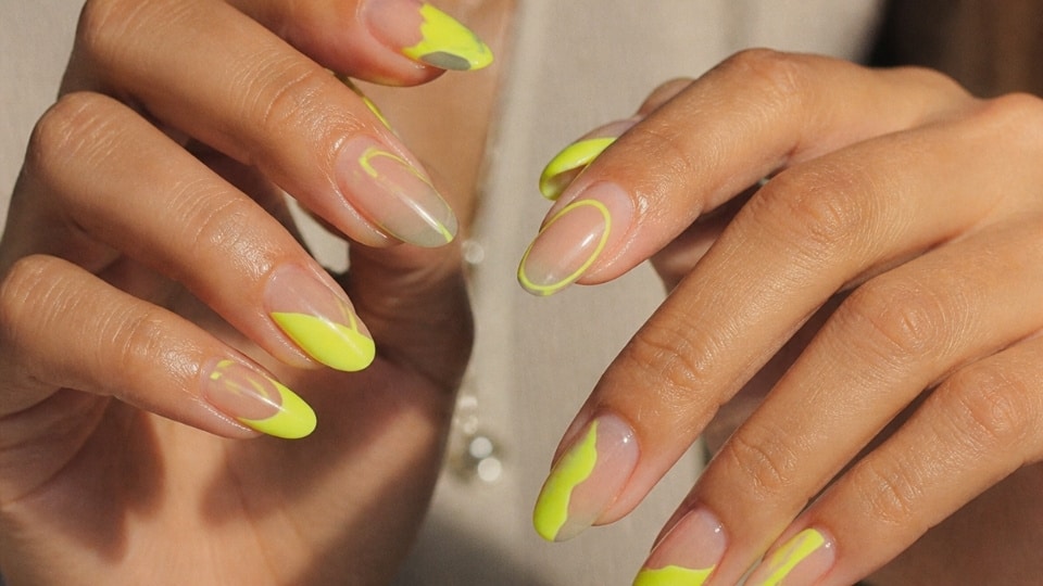 Neon yellow negative space nails with geometric shapes and abstract glossy nail art details