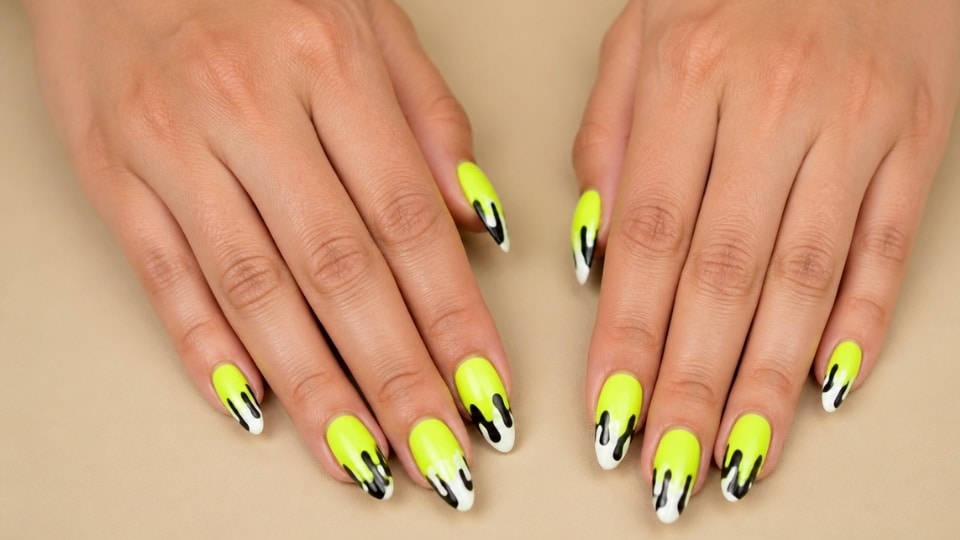 Neon yellow drip nails with black and white flowing details and artistic glossy finish