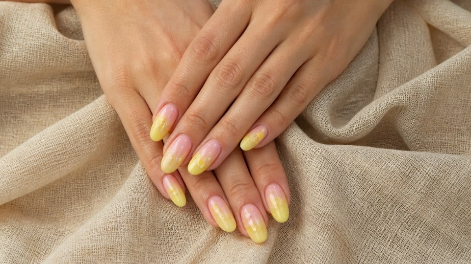 Pink and neon yellow ombre nails with smooth gradient blending and glossy almond shapes