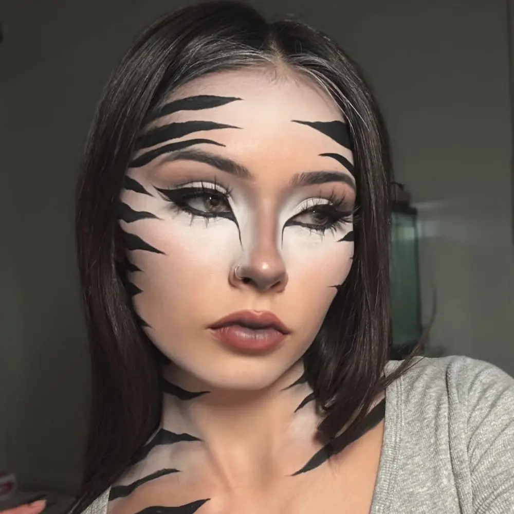 Scaredy cat makeup with a pink triangle nose, thin black whiskers, a soft smoky eye, and small white highlight dots