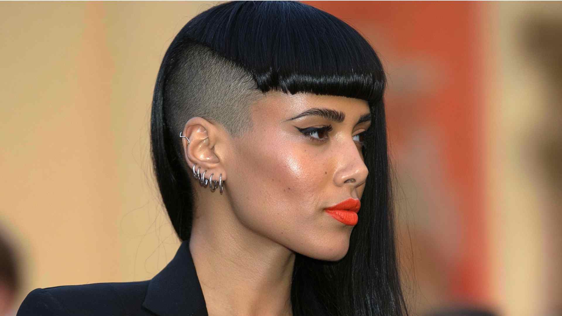 Alternative short haircut with one shaved side and a long sweeping fringe