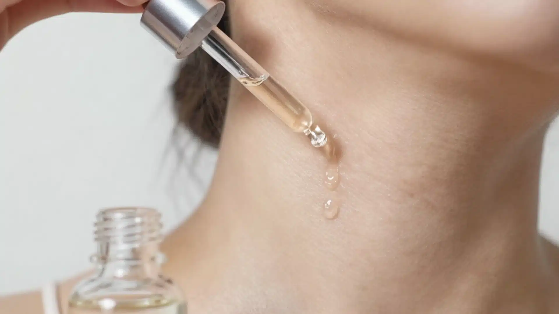 Skincare routine on neck with serum and moisturizer
