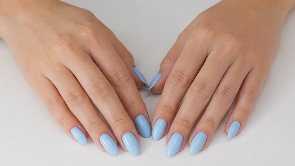 hands showing soft sky blue nails with a glossy finish and fresh pastel manicure style