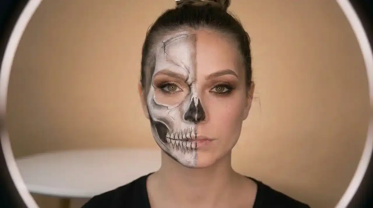 Close up Halloween makeup tutorial showing skull face painting details blended with a glamorous makeup look on half the face