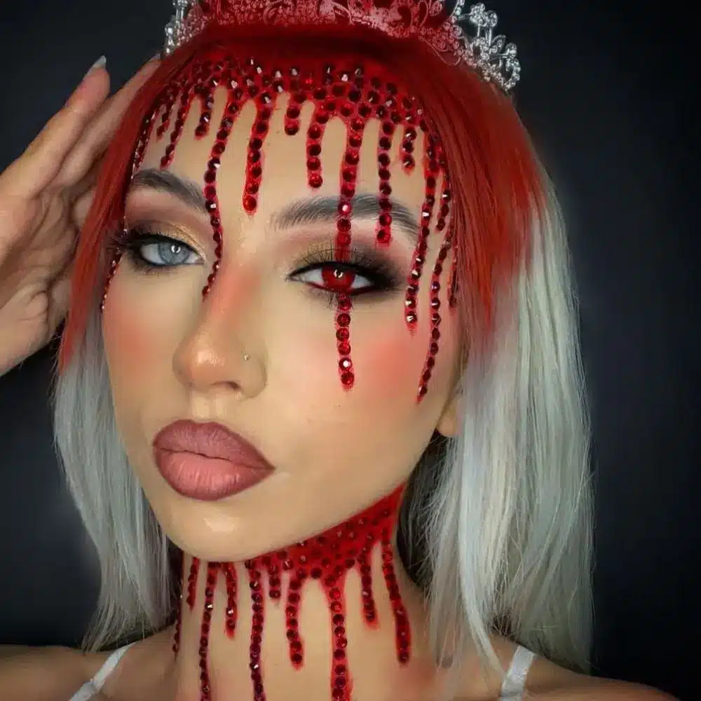 Carrie prom makeup with fresh blush and mascara under realistic fake blood dripping from the hairline over her face