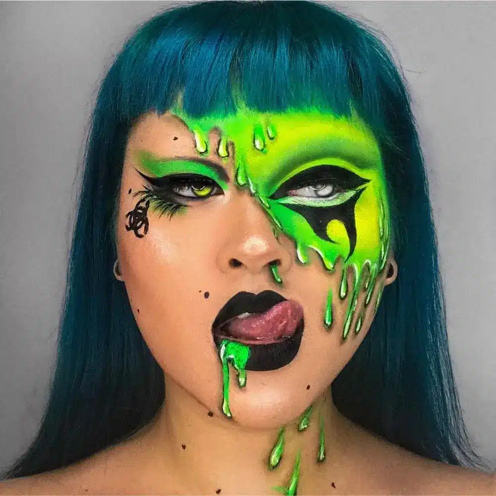 Toxic spill makeup with bright green skin, black damaged patches, and sticky green drips running down face and neck