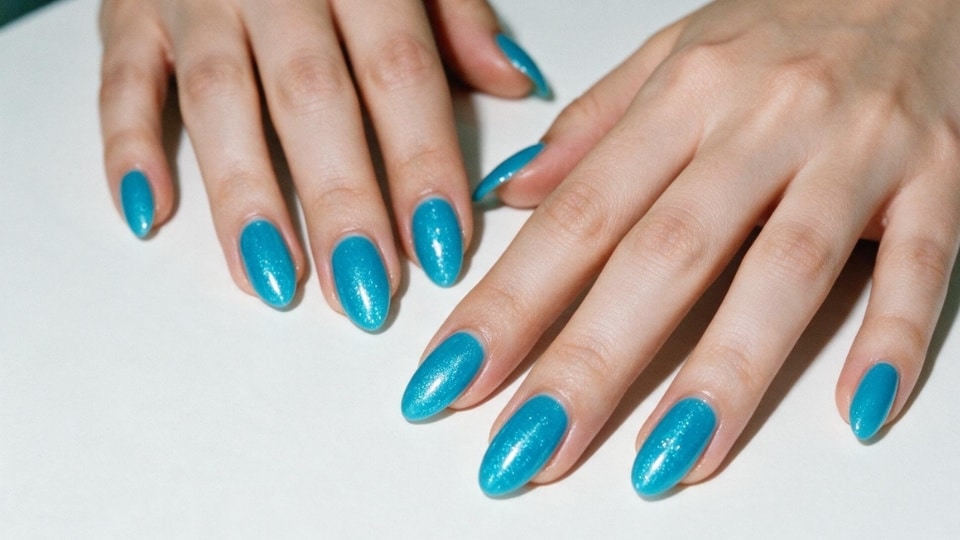 Hands featuring turquoise blue nails with a vibrant glossy finish